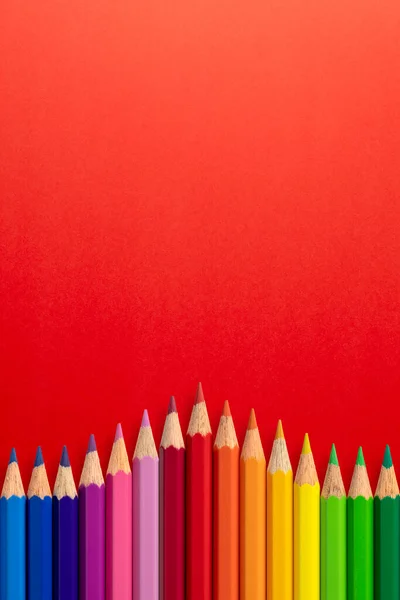 Творческий Вертикальный Фон Цветных Карандашей Красной Бумаге Плоский Лежал Концепция — стоковое фото