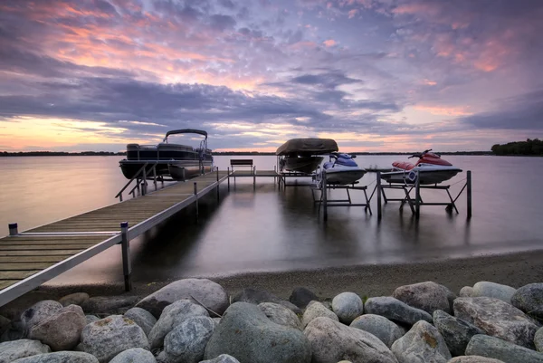 Bootsanlegestelle bei Sonnenuntergang mit erhöhten Booten und Jetskis, Minnesota, USA — Stockfoto