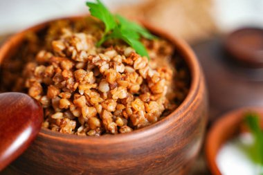 Karabuğday lapasıyla maydanozu karıştırmaya odaklan. Kahvaltı, sağlıklı yiyecekler. Kapat.