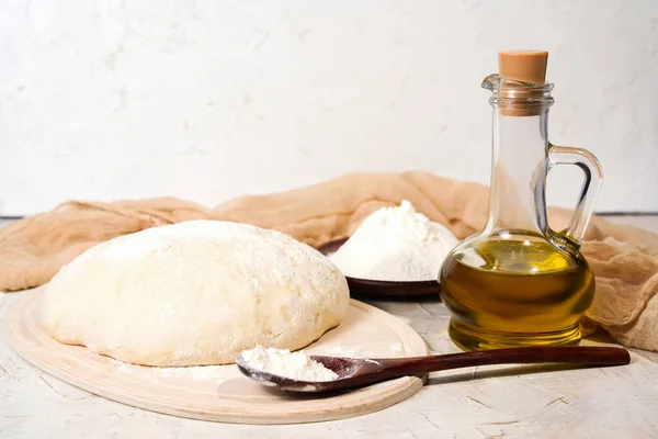 キッチンテーブルの上に生地のボール,コピースペース付きボトルのオリーブオイル.ピザ生地を混練。素朴なパン自家製 — ストック写真