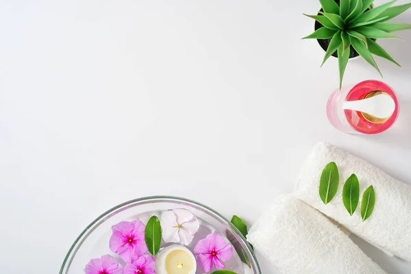 Fond délicat, gel hygiénique intime, serviettes blanches et un récipient avec des fleurs roses pour l'aromathérapie. Espace de copie. — Photo