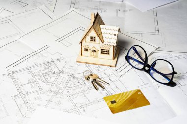 Bir ev ve anahtarlık modeli, proje planı ve kopya alanı olan çizimler