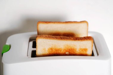 Tost makinesinde iki dilim sıcak ekmek. İlk parçaya seçmeli odak, bulanık arkaplan