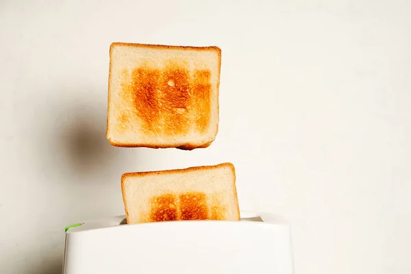 Tostadora con rebanadas de pan sobre fondo blanco de cerca, espacio para texto —  Fotos de Stock