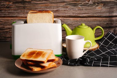 Ekmek dilimli tost makinesi. Elektrikli ekmek kızartma makinesi, beyaz arka planda iki sıcak ekmek dilimi var..