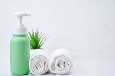 Kozmetik şişeleri ve beyaz havlu masa boş arkaplanda. Daha fazla eşya seti. Spa nesneleri..