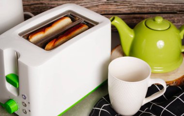 Tost makinesi ve iki sıcak tost kahvaltıya hazır.