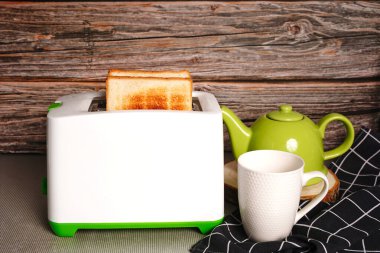 Ekmek dilimli tost makinesi. Elektrikli ekmek kızartma makinesi, beyaz arka planda iki sıcak ekmek dilimi var..