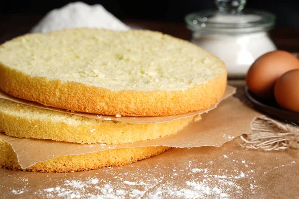 Cortar o biscoito em camadas. Fatiando bolo de esponja em casa na cozinha. — Fotografia de Stock