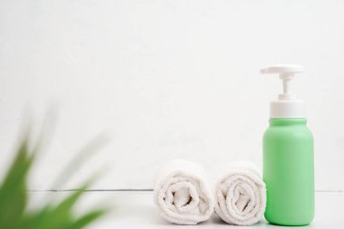 Kozmetik şişeleri ve beyaz havlu masa boş arkaplanda. Daha fazla eşya seti. Spa nesneleri..