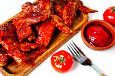 Beyaz arka planda izole edilmiş domates soslu tavuk kanadı.