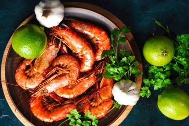 Tabakta kızarmış Langoustines ve karides. Sarımsak ve limon turşusu..