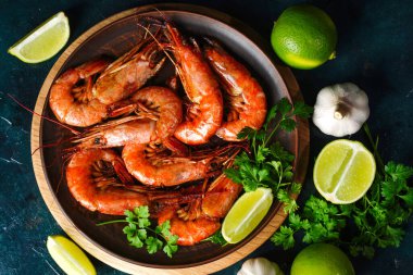 Kızarmış langoustine 'leri ve karidesleri maydanozlu bir tabağa koy. Sarımsak ve limon turşusu. Üst görünüm