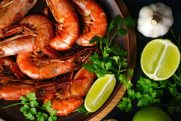 Sluiten Gefrituurde langoustines en garnalen op een bord. Gekneusd in knoflook en limoen. Bovenaanzicht — Stockfoto