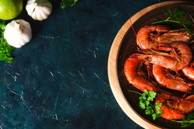 Izgara Arjantin karidesleri, karides langoustines otlu, sarımsak ve limonlu koyu bir arka plan, üst manzara