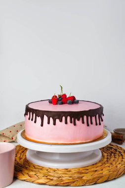 Taze meyve ve çikolata parçasıyla süslenmiş çilekli yoğurt pastası. Sevgililer Günü ya da doğum günü partisi için lezzetli ve pembe bir pasta. Ev yapımı fırın konsepti