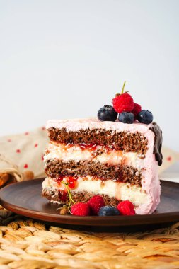 Lezzetli ev yapımı çikolatalı pasta kakao ve taze süt kremi, pembe peynir kremi. Uzayı kopyala Böğürtlen ve reçelle süslenmiş. Kopyalama alanı olan yan görünüm. Tatlı ve rahatlatıcı konsept.
