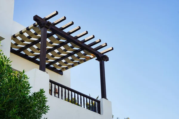 The sun canopy of wood beams on blue sky background.