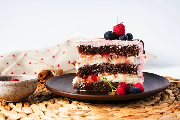 Homemade sponge cake with berries, pink cream and chocolate. Selective focus with copy space. — Stock Photo, Image