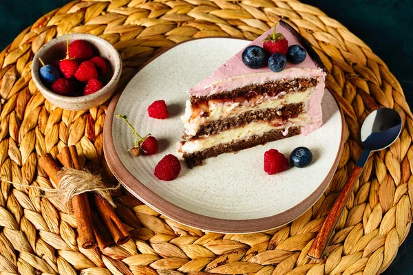 Piece of cake, chocolate biscuit with cream cheese filling. Berries on pink cream decoration. Top view — Stock Photo, Image