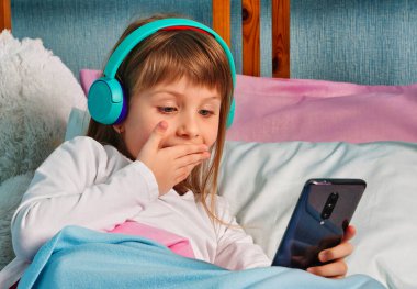 Kameraya bakarak sohbet eden, web kamerasıyla konuşan, gülümseyen, online video görüşmesi yapan, video blogu kaydeden, evde yatağında oturan,