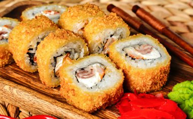 Tempura suşi rulo karides, pastırma ve Philadelphia peyniri ahşap bir tabakta yakın çekim