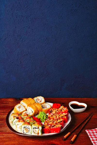Rolls conjunto servido na placa em fundo azul escuro com espaço de cópia. Jantar japonês de sushi menu para dois. Vista horizontal superior de cima — Fotografia de Stock