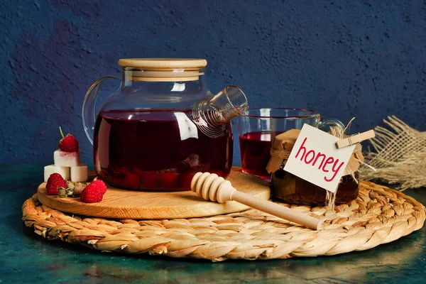 Honey, berry fruit tea and honeysuckle on dark blue background