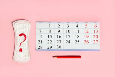 Adet takvimi, kadınlarda düzenli döngünün kontrolü, kalem ve hijyenik ped peçetesi..