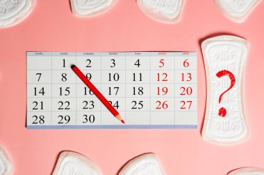 Adet günleri ürünleri, pembe arka planda kırmızı tarihli takvim 