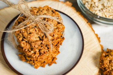 Yulaflı kurabiyeler, sağlıklı kahvaltı gevreği yulaf krakerleri ve yulaf gevreği. Kırsal masada gevrek anzak bisküvisi.