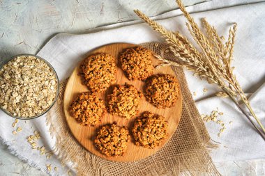 Yulaflı kurabiyeler manzarayı kapatır. Ev yapımı lezzetli rulo yulaf kurabiyeleri masa peçetesi, yulaf ezmesi ve süt şişesi. Sabah kahvaltı masası arka planı.