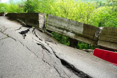 Deprem yüzünden asfalt yolu çatlamış ve kırılmış.