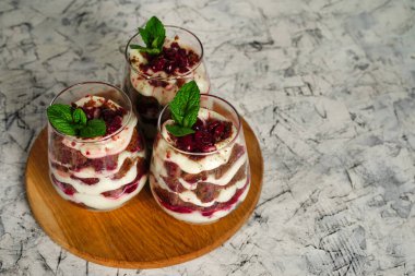 Şeffaf bardakta çikolatalı ve beyaz kremalı kahverengi süngerli tatlı. Pasta nane yaprağı ve doğum günü pastasıyla süslenmiş. Yüksek kalite fotoğraf