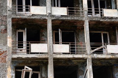 Terk edilmiş çok katlı bir binanın parçalarını kapatın. Mahvolmuş balkonlar, pencere ve kapı yok. Yüksek kalite fotoğraf