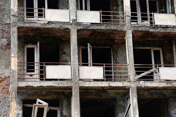Terk edilmiş çok katlı bir binanın parçalarını kapatın. Mahvolmuş balkonlar, pencere ve kapı yok. Yüksek kalite fotoğraf