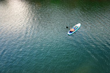 Paddleboard SUP Man 'in en iyi görüntüsü. Fitness eğlence amaçlı eğlence aktivitesi. Seyahat için kiralanan plaj malzemeleri. Yüksek kalite fotoğraf
