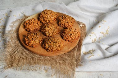 Yulaflı kurabiyeler manzarayı kapatır. Ev yapımı lezzetli rulo yulaf kurabiyeleri masa peçetesi, yulaf ezmesi ve süt şişesi. Sabah kahvaltı masası arka planı. Yüksek kalite fotoğraf