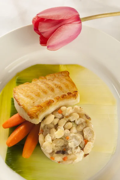 Bodegón de una cena de mariscos pescado al horno sobre una placa blanca. — Foto de Stock