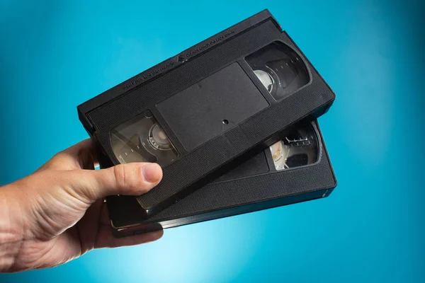 Hand Holds Two Retro Hvs Video Cassette Blue Background Retro Stock Image