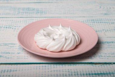 Pembe bir tabakta büyük bir krema. Ev yapımı şekerleme. Eski beyaz ve mavi masa.