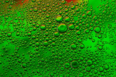 Yeşil renkli arka planda suda yağ kabarcıkları