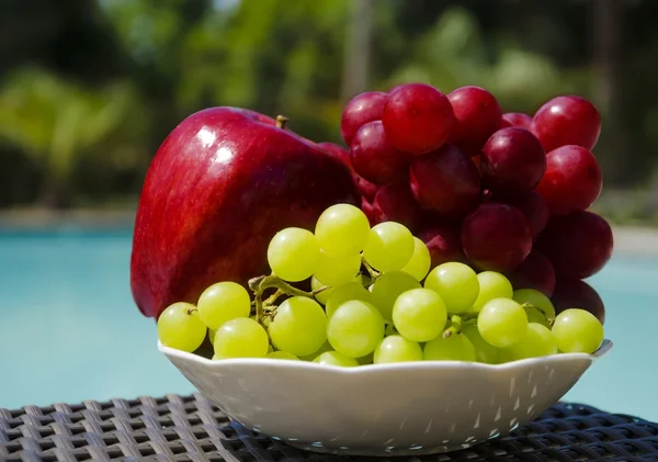 Pomme et raisin au bord de la piscine — Photo