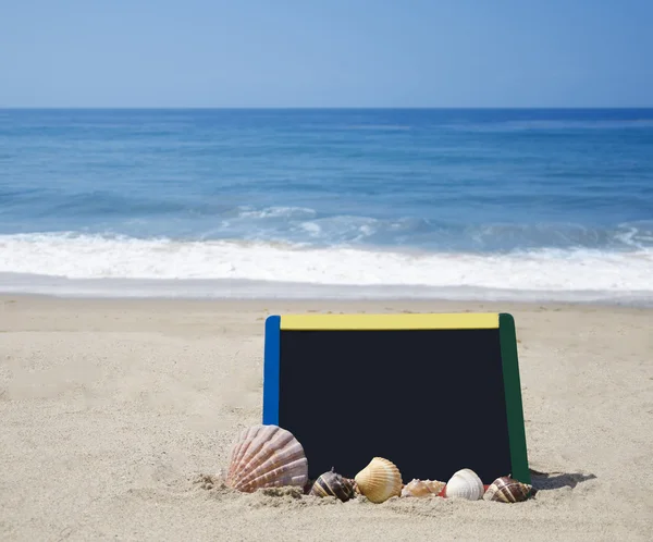 Zwarte board op zandstrand — Stockfoto