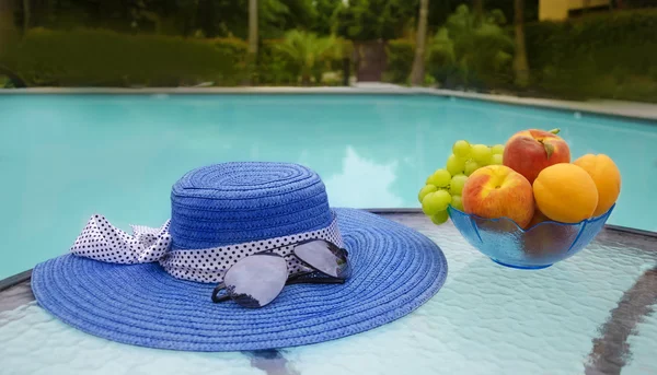 Шапка і фрукти біля басейну для плавання — стокове фото