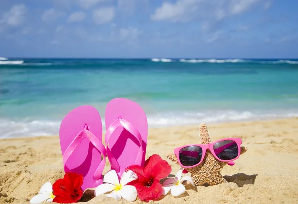 Flip flops and starfish with sunglasses on sandy beach — Stock Photo, Image