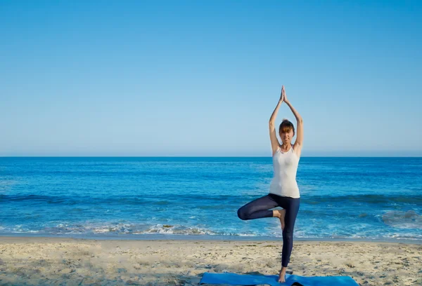 yang kadın okyanus tarafından Yoga uygulamak