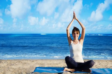 yang kadın okyanus tarafından Yoga uygulamak