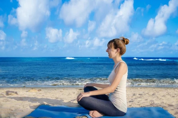 Yang kvinna utövar yoga av havet — Stockfoto