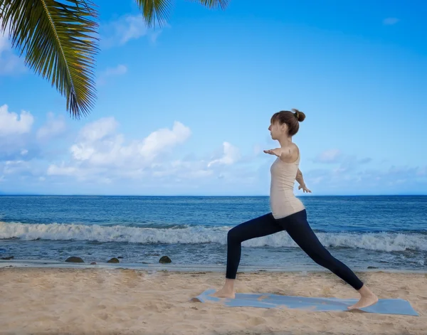 Yang kvinna utövar yoga av havet — Stockfoto
